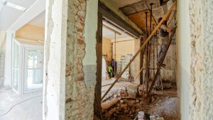 Renovatiebudget toepassen bij constructiewerk met open muren, balken en vakmensen tijdens verbouwing