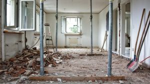 Renovatiebudget zichtbaar bij sloopwerk in woning met puin, stempels en opengebroken vloer