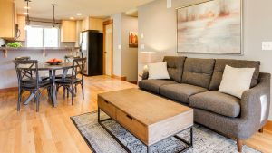 Compacte woonkamer indeling met open keuken, houten meubels en warme verlichting voor een huiselijke sfee