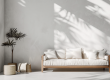 Strak afgewerkte muur in een minimalistische woonkamer met bank en plant.