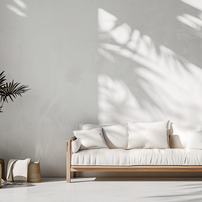 strakke-muur-afwerking-in-woonkamer Strak afgewerkte muur in een minimalistische woonkamer met bank en plant.